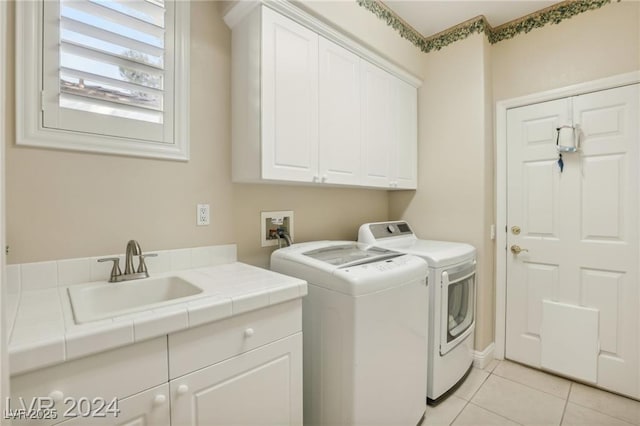 washroom featuring washer and dryer, cabinet space, a sink, and light tile patterned flooring