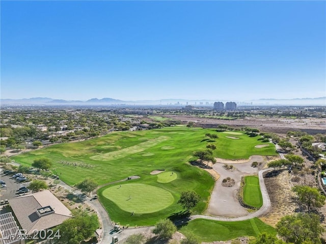 aerial view featuring view of golf course, a mountain view, and a city view