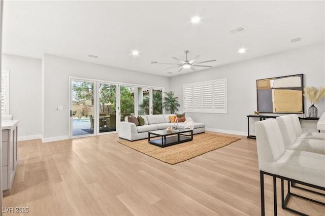 living area featuring baseboards, light wood-style flooring, visible vents, and recessed lighting