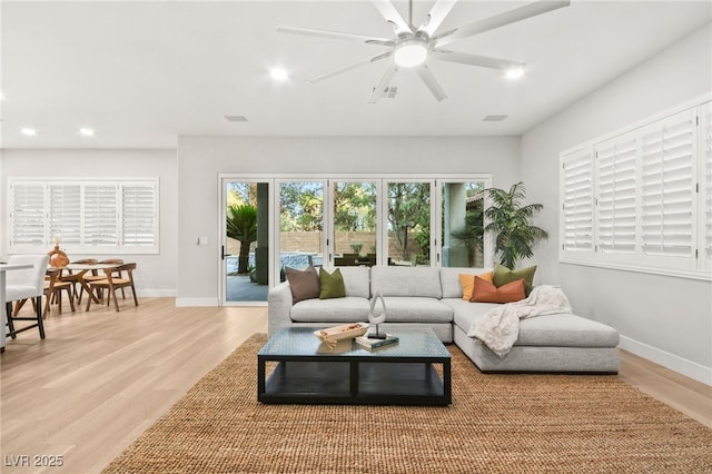 living area with light wood-type flooring, baseboards, and recessed lighting