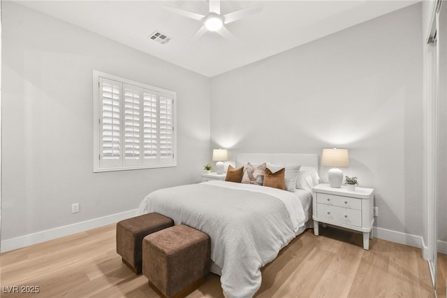 bedroom featuring light wood-style floors, visible vents, and baseboards