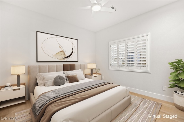 bedroom with light wood-type flooring, a ceiling fan, and baseboards