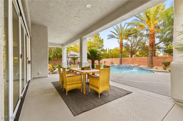 view of patio featuring outdoor dining space, a fenced backyard, and a fenced in pool