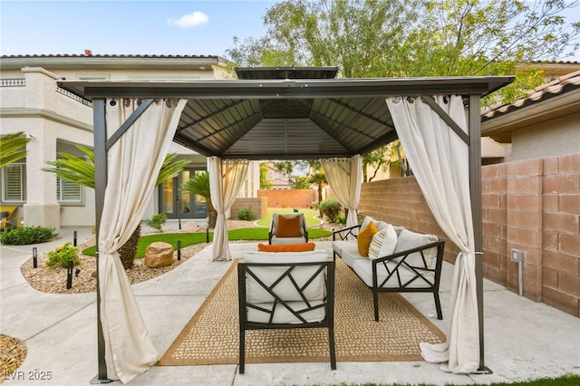 view of patio / terrace with a gazebo, fence, and an outdoor living space