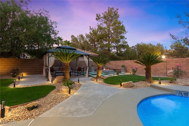 pool at dusk featuring a fenced in pool, a patio area, a lawn, and a fenced backyard