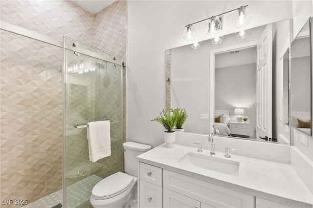 bathroom featuring toilet, a shower stall, vanity, and ensuite bathroom