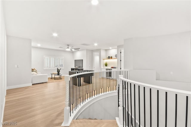 hall with recessed lighting, visible vents, an upstairs landing, light wood-type flooring, and baseboards