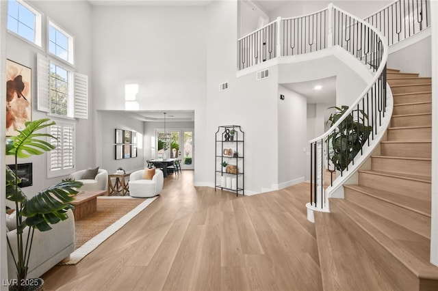 entryway with plenty of natural light, visible vents, wood finished floors, and a glass covered fireplace