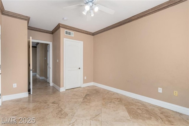 spare room featuring crown molding, a ceiling fan, visible vents, and baseboards