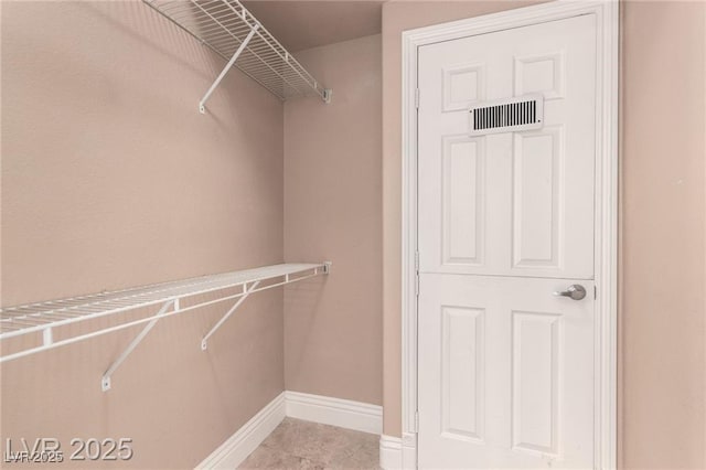 spacious closet featuring visible vents and light tile patterned floors