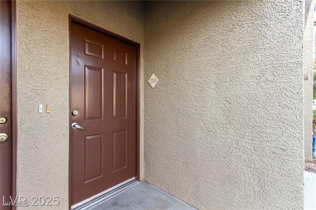 doorway to property featuring stucco siding