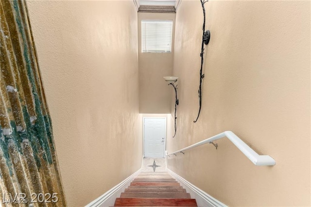 stairway featuring baseboards and wood finished floors