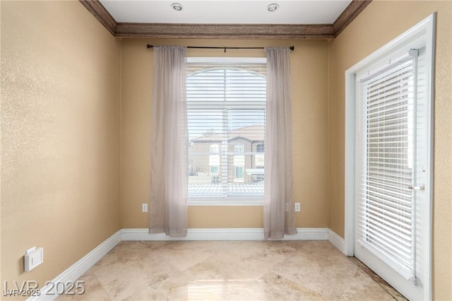 spare room with baseboards and ornamental molding