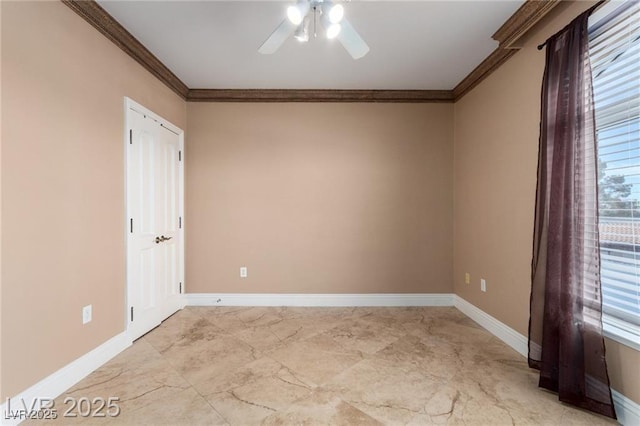 empty room featuring a ceiling fan, marble finish floor, crown molding, and baseboards