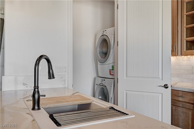 clothes washing area with laundry area and stacked washer / dryer