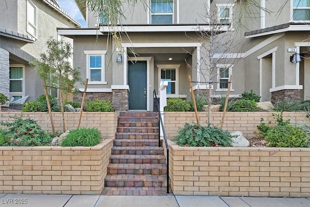 view of exterior entry with stone siding and stucco siding