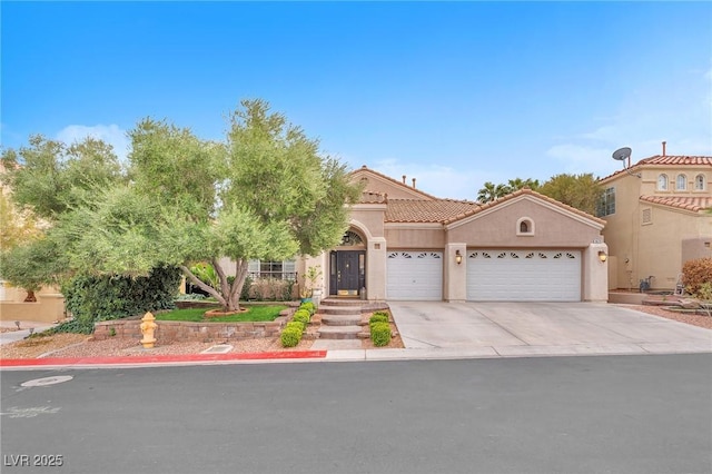 mediterranean / spanish house featuring stucco siding, a tiled roof, an attached garage, and driveway