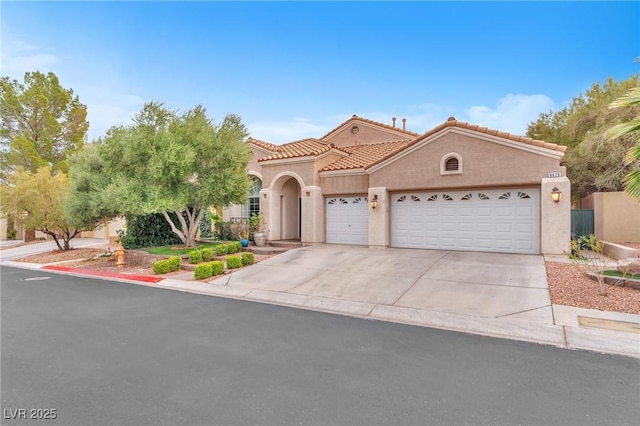 mediterranean / spanish-style house featuring stucco siding, an attached garage, driveway, and a tiled roof