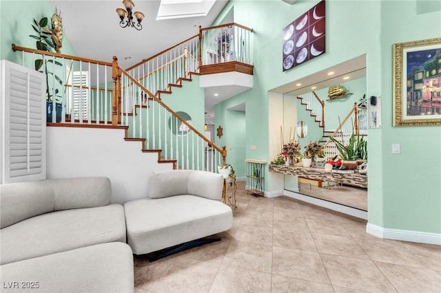 living area with baseboards, a high ceiling, stairs, and tile patterned flooring