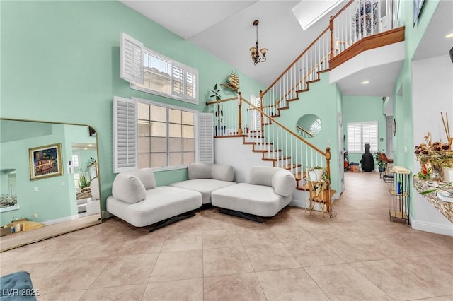 tiled living room with stairs, baseboards, a towering ceiling, and a chandelier