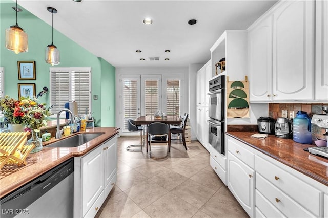 kitchen featuring a sink, french doors, appliances with stainless steel finishes, and white cabinetry