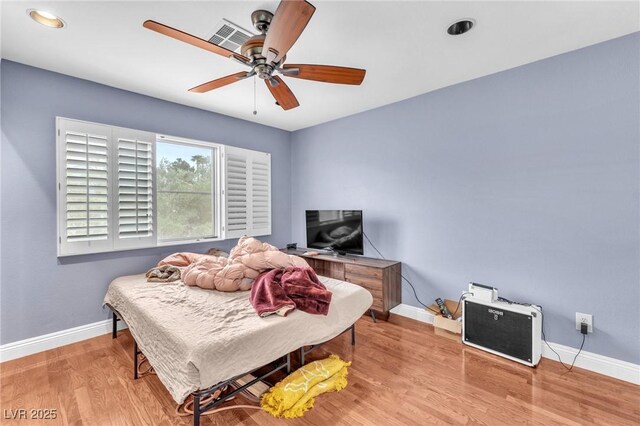 bedroom featuring visible vents, baseboards, wood finished floors, and a ceiling fan