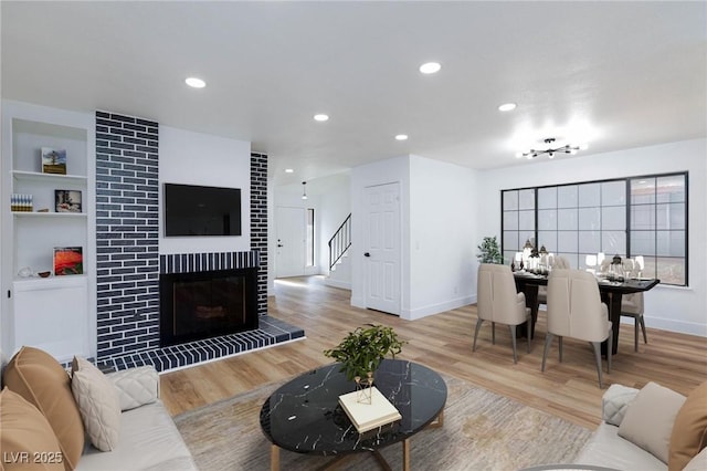 living area with recessed lighting, baseboards, wood finished floors, and a tiled fireplace