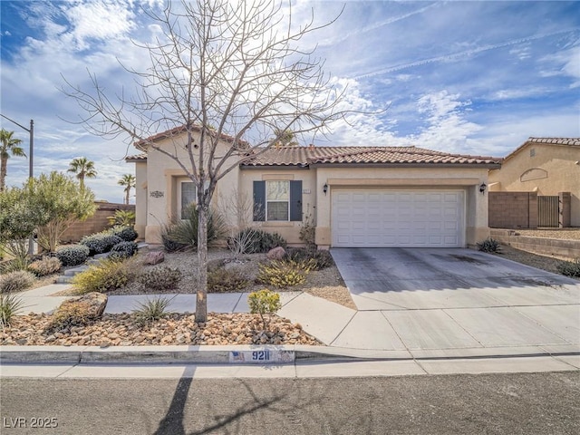 mediterranean / spanish-style home with driveway, an attached garage, a tiled roof, and stucco siding