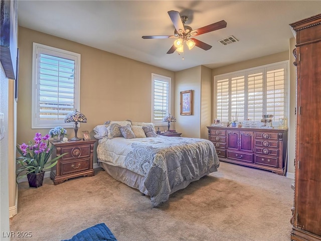 bedroom featuring light carpet, ceiling fan, visible vents, and baseboards