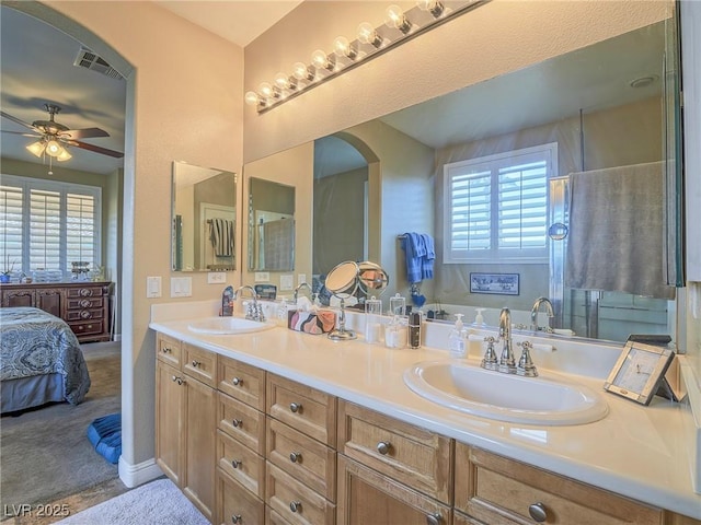 ensuite bathroom with visible vents, connected bathroom, a sink, and double vanity