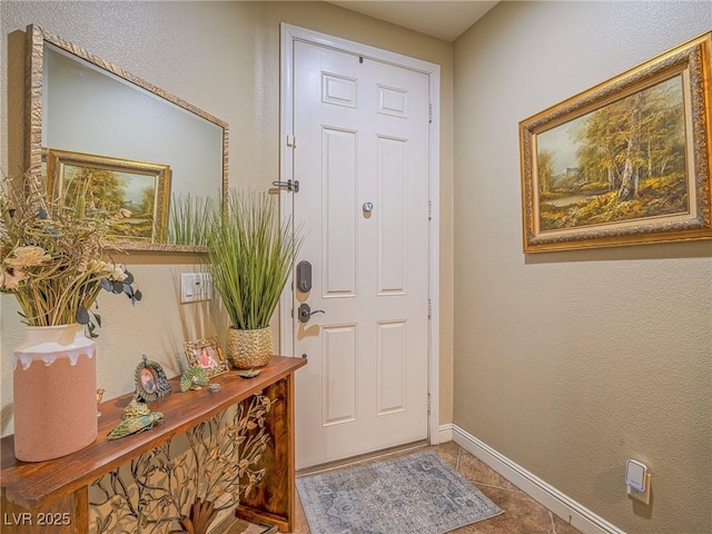 doorway with baseboards and tile patterned floors