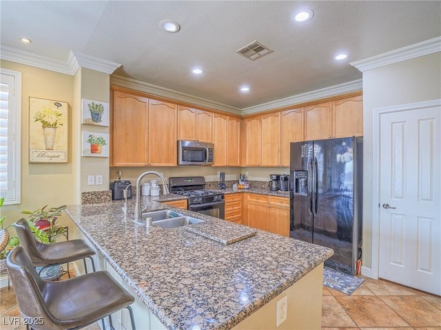 kitchen with dark stone counters, a peninsula, crown molding, black appliances, and a sink