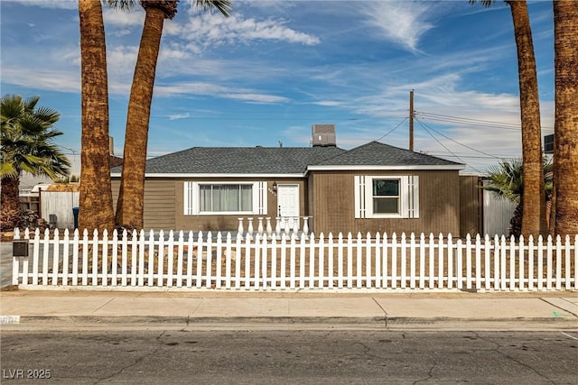 view of front of home featuring roof with shingles and a fenced front yard