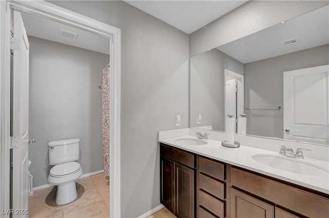 full bath featuring toilet, double vanity, a sink, and visible vents