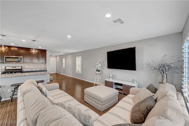 living area featuring baseboards, visible vents, dark wood finished floors, and recessed lighting