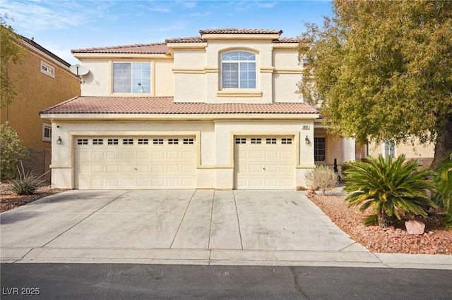 mediterranean / spanish house with an attached garage, a tile roof, concrete driveway, and stucco siding