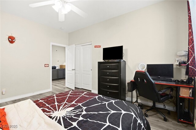 bedroom featuring a ceiling fan, a closet, baseboards, and wood finished floors