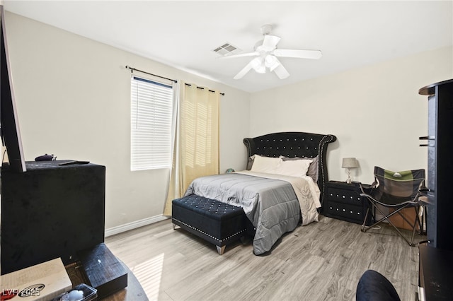 bedroom with visible vents, a ceiling fan, light wood-style flooring, and baseboards