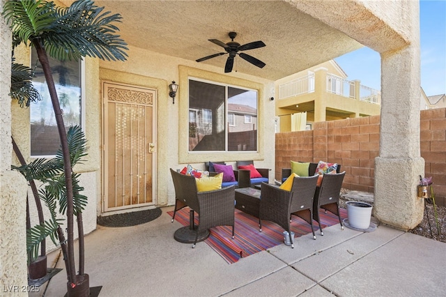 view of patio with ceiling fan, an outdoor living space, and fence