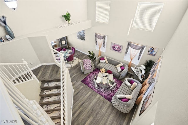 living room featuring stairway, baseboards, and wood finished floors