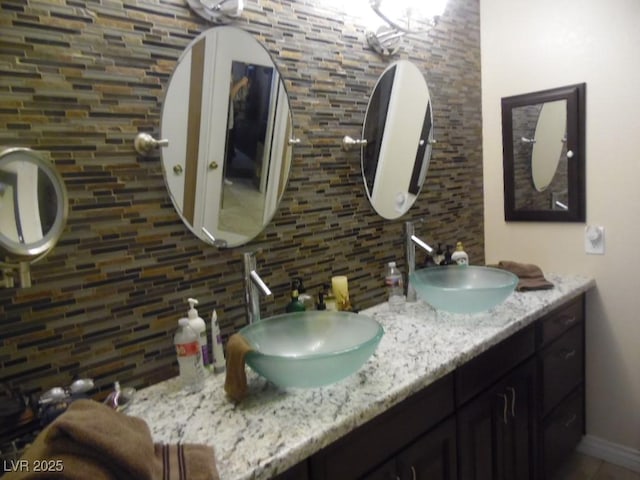 bathroom with double vanity, decorative backsplash, and a sink