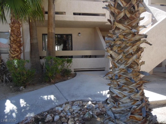 view of exterior entry featuring a baseboard radiator and stucco siding