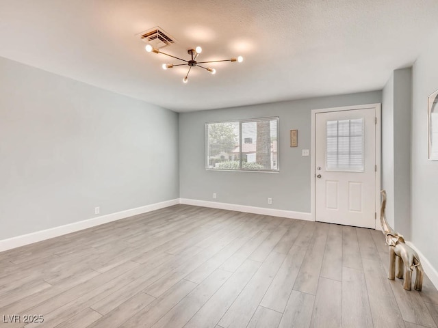 entrance foyer featuring visible vents, baseboards, and wood finished floors