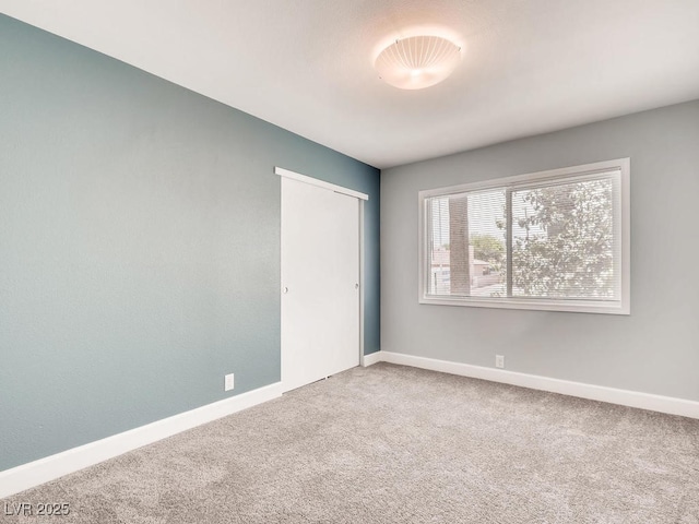 carpeted empty room with baseboards