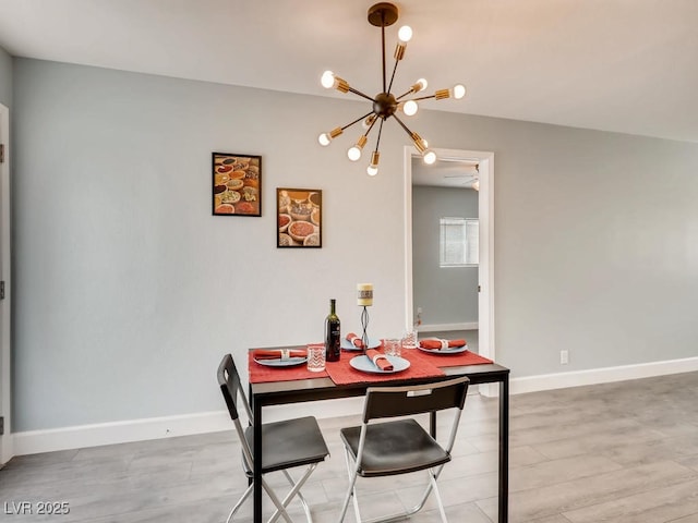 dining space featuring a notable chandelier, light wood-style flooring, and baseboards