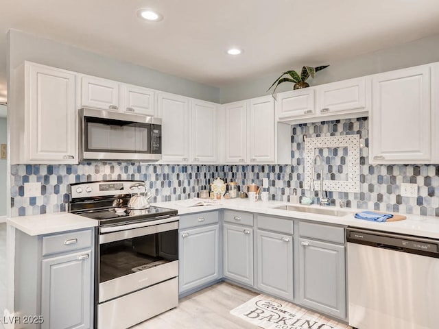 kitchen featuring stainless steel appliances, light countertops, and a sink