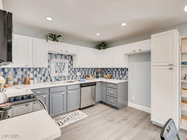 kitchen featuring a sink, white cabinets, light wood-type flooring, gray cabinets, and dishwasher