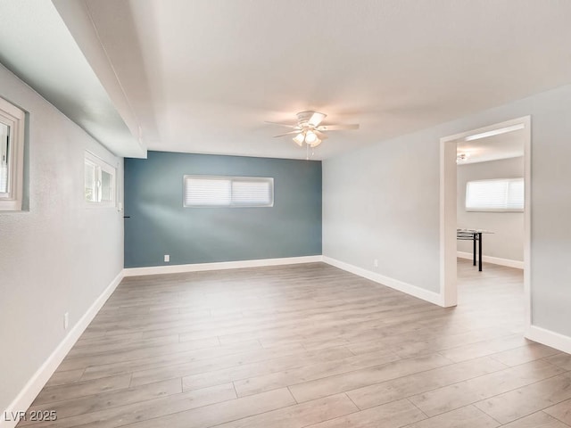 unfurnished room with baseboards, ceiling fan, and light wood-style floors