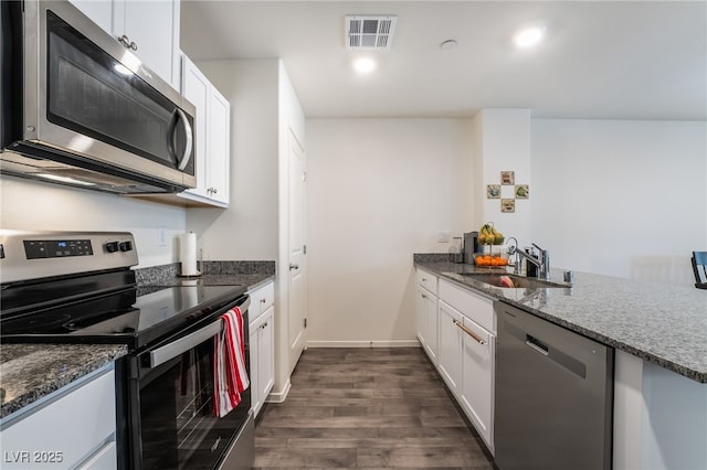 kitchen featuring visible vents, white cabinetry, stainless steel appliances, and a sink