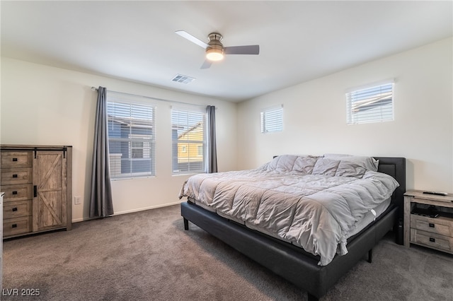 bedroom with a ceiling fan, visible vents, dark carpet, and baseboards